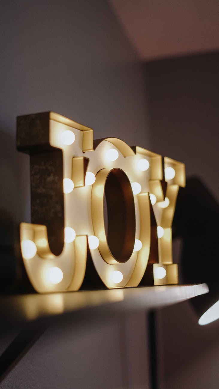 selective focus photography of joy free standing letters with lights